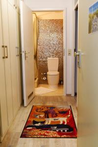 a bathroom with a toilet and a rug on the floor at Appartement "Weitblick" in Heiligenhafen