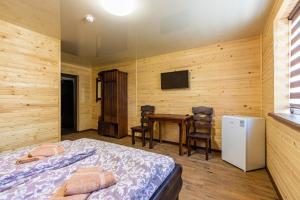 Schlafzimmer mit einem Bett, einem Tisch und einem TV in der Unterkunft Комплекс СільДар in Solotwyno
