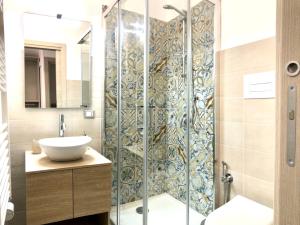 La salle de bains est pourvue d'une douche en verre et d'un lavabo. dans l'établissement I MORI - Holiday Rooms, à Lascari
