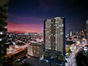 um horizonte da cidade à noite com um edifício alto em Central Makati Condo w/ Balcony near Commercial Areas em Manila