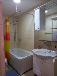 ein Bad mit einer Badewanne, einem Waschbecken und einer Dusche in der Unterkunft D,apartman in Omišalj