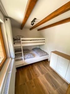 two bunk beds in a room with a wooden floor at Chata TRI GROŠE 1 in Námestovo