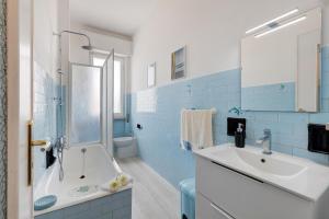 a bathroom with a tub and a sink at Riva Mare 1 in Vado Ligure +13 photos