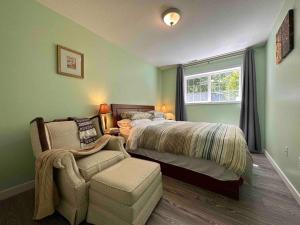 ein Schlafzimmer mit einem Bett, einem Stuhl und einem Fenster in der Unterkunft Countryroad Cozy 2 Bedrooms basement suite1 in Nanaimo