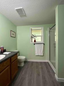 baño con aseo y lavabo y ventana en Countryroad Cozy 2 Bedrooms basement suite1 en Nanaimo