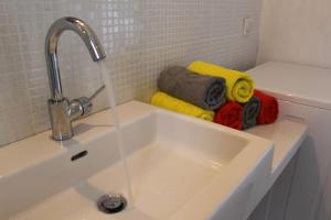 a white sink with a faucet and some towels at Ferienwohnung direkt am Strand in Ierapetra