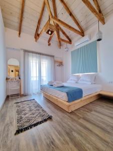 um quarto com uma cama grande num quarto com tectos em madeira em Votsalo Cozy Apartments em Limenaria
