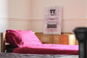 Una cama con una sábana rosa encima. en Lavish 2 bed sleeps 5 near Lanark, en Carstairs