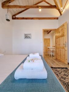two beds in a room with a table at Votsalo Cozy Apartments in Limenaria