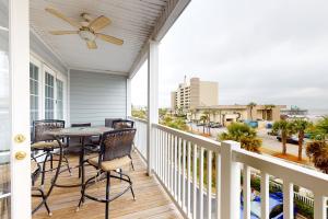 a porch with a table and chairs and a ceiling fan at Pavilion Watch #2E in Folly Beach
