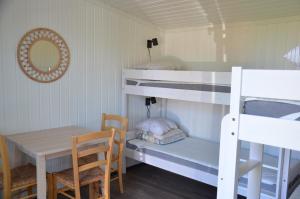 a room with bunk beds and a table and a table and chairs at Käringsund Resort Camping in Eckerö