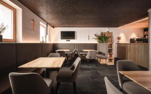 une salle à manger avec des tables et des chaises en bois dans l'établissement Hotel Fernblick, à Bressanone