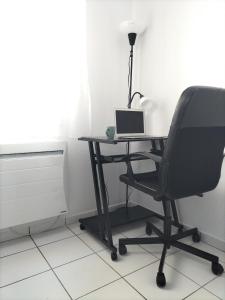 uma secretária com uma cadeira e um computador portátil em Appartement aux portes de Bordeaux em Pont-de-la-Maye