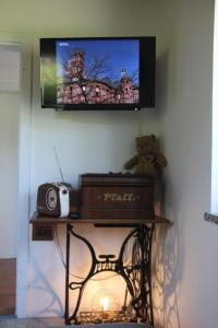 una tv su un muro con un orsacchiotto sul tavolo di Ferienhaus Kärntnergmiat a Feldkirchen in Kärnten