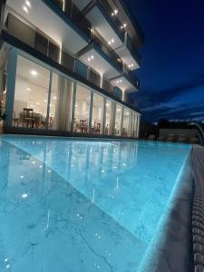 a swimming pool in front of a house at night at Hotel Ascot Riccione in Riccione