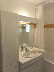 uma casa de banho branca com um lavatório e um espelho em Appartement aux portes de Bordeaux em Pont-de-la-Maye