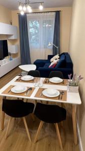 a living room with a table and a blue couch at Apartament Mariacka in Mława