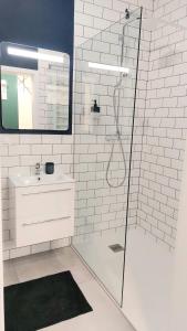 a white bathroom with a shower and a sink at Apartament Mariacka in Mława
