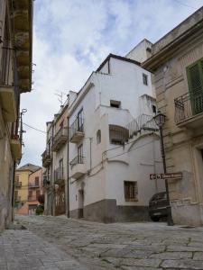a white building with balconies on a street at Il Paese Alberga! in Caulonia