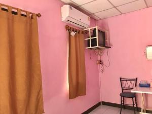 a room with a pink wall with a window and a curtain at แสงสง่ารีสอร์ท Saeng Sa-Nga Resort 