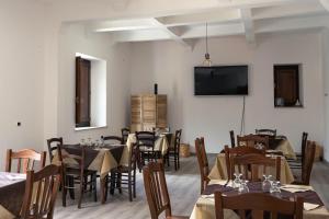 a dining room with tables and chairs and a flat screen tv at Il Paese Alberga! in Caulonia