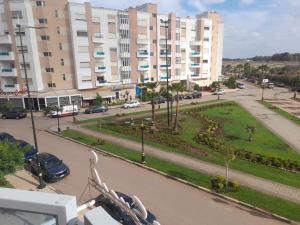 a view of a park in front of a large building at Près de l Airopor mohammed 5 in Nouaceur