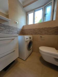 a bathroom with a washing machine and a toilet at New 1 bedroom near Center and beach in Split