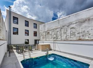 un edificio con piscina al lado de un edificio en Hostelfly, en Madrid