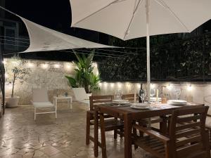 a wooden table with chairs and an umbrella at CORTILET in Fasano