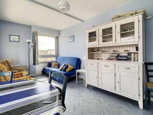 un salon avec un canapé bleu et une grande armoire dans l'établissement Appartement Cucq-Stella Plage, 2 pièces, 4 personnes - FR-1-236-64, à Stella-Plage