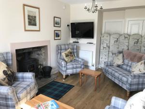 a living room with two couches and a fireplace at The Struan Inn Self Catering Lodge in Struan
