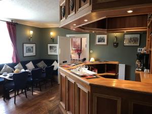 een keuken en een woonkamer met een tafel en een bank bij The Struan Inn Self Catering Lodge in Struan
