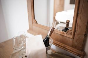 a bottle of wine sitting on a table in front of a mirror at Hotel Fernblick in Bressanone +70 photos