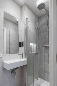 a white bathroom with a sink and a shower at Mornington Victor Hotel London Belgravia in London