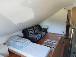 a living room with a couch and a bed at Zakątek Pod Lasem in Wydminy