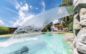 a water fountain in a swimming pool at Hotel Fernblick in Bressanone