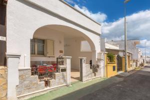 un edificio blanco con un arco en una calle en Casa di Enza by BarbarHouse, en Torre San Giovanni