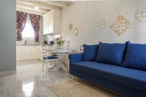 a living room with a blue couch and a kitchen at Nafsika Suites in Nea Moudania