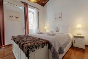 a white bedroom with a bed and a window at Cozy Corfiot house in Corfu Town