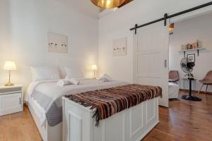 a white bedroom with a bed with a blanket on it at Cozy Corfiot house in Corfu Town