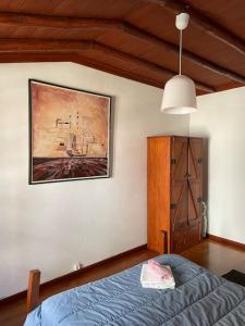 1 dormitorio con 1 cama y una pintura en la pared en Casa da Portela en Penacova