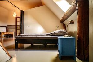 Кровать или кровати в номере Loft in romantische stolpboerderij bij duingebied.