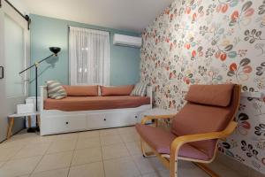 a bedroom with a bed and a chair in it at Cozy Corfiot house in Corfu Town