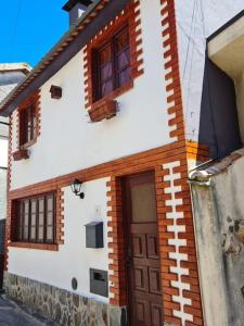 Casa blanca con puerta y ventanas marrones en Casa da Portela en Penacova