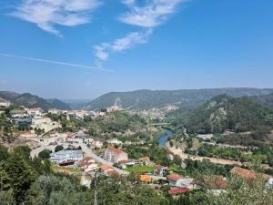 a view of a town with a river and mountains at Casa da Portela in Penacova