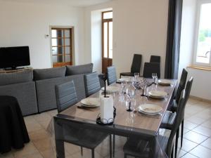 een eetkamer met een tafel en een bank bij Gîte Oradour-Fanais, 4 pièces, 6 personnes - FR-1-653-133 in Oradour-Fanais