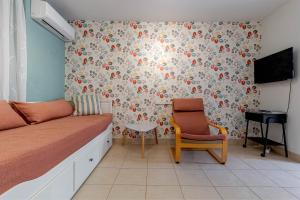 a room with a bed and a chair and a tv at Cozy Corfiot house in Corfu Town