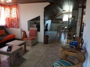 a living room with a couch and chairs and a kitchen at Villa Ylagiali in Plataria