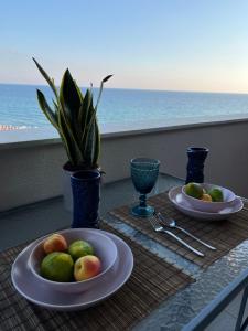 una mesa con platos de fruta en una mesa con el océano en Costal apartment en Glyfada