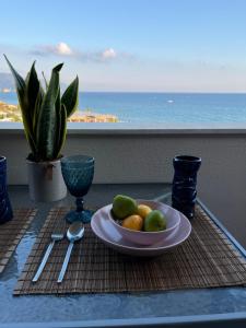 a plate of fruit on a table with a view of the ocean at Costal apartment in Glyfada